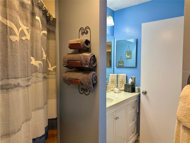 bathroom featuring vanity, curtained shower, and a textured ceiling