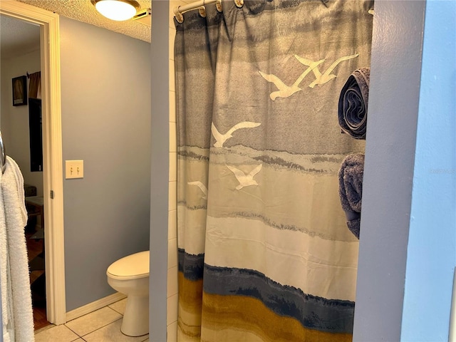 bathroom featuring tile patterned flooring, a textured ceiling, and toilet