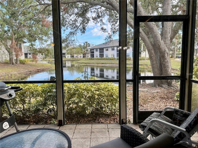 sunroom featuring a water view