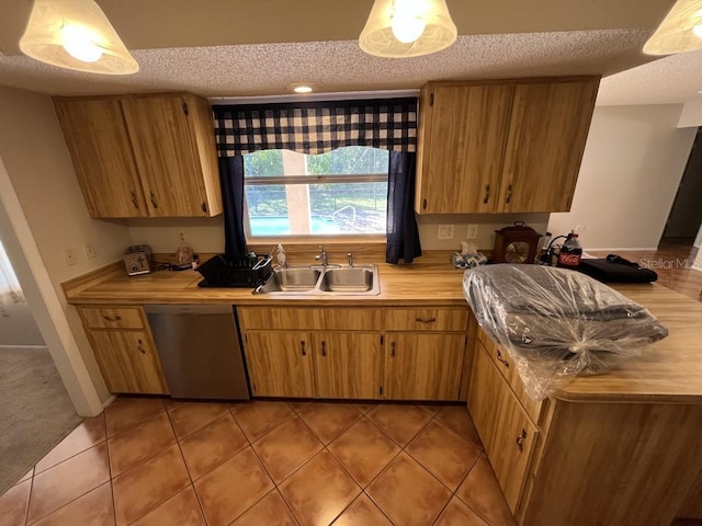 kitchen with light tile patterned flooring, a textured ceiling, stainless steel dishwasher, and sink