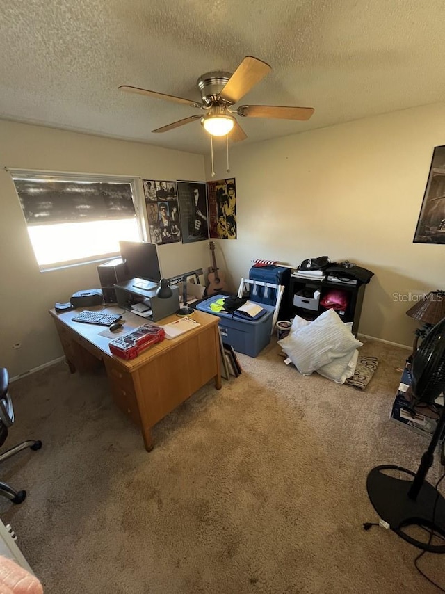 carpeted office space with a textured ceiling and ceiling fan