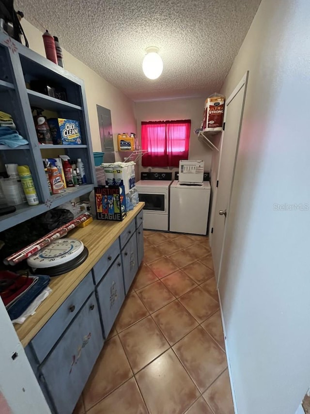 interior space featuring tile patterned floors, separate washer and dryer, and a textured ceiling