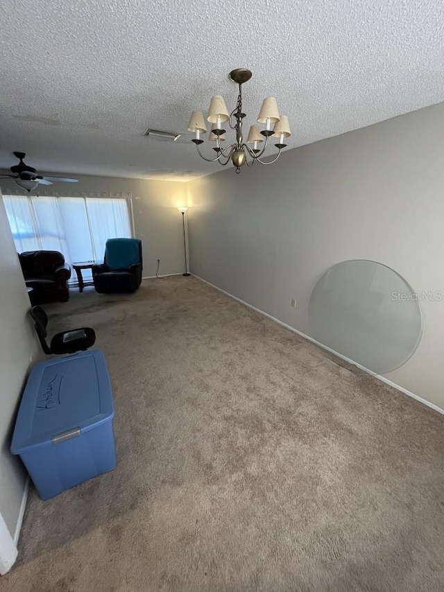 living area with carpet, a textured ceiling, and ceiling fan with notable chandelier