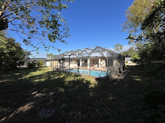 view of pool with a lanai and a lawn