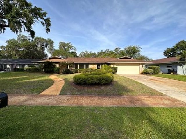 ranch-style house featuring a front yard and a garage