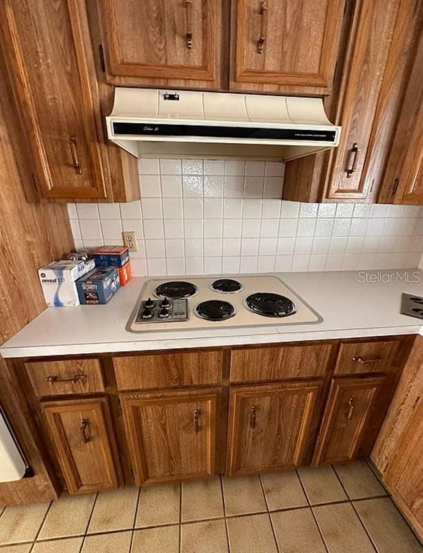 kitchen featuring tasteful backsplash, white gas stovetop, and light tile patterned flooring