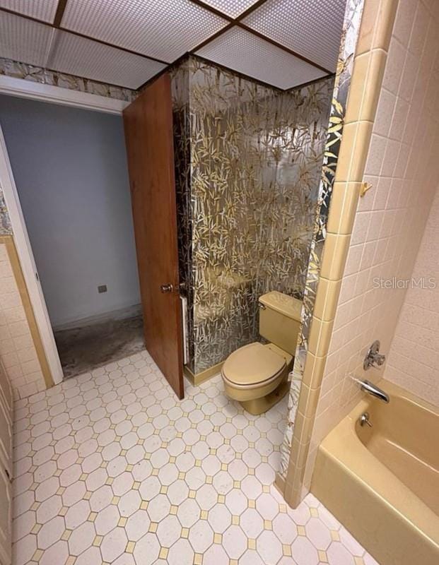 bathroom with toilet and bathing tub / shower combination