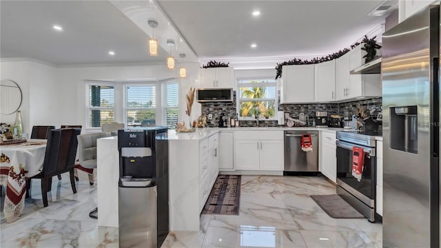 kitchen with white cabinets, decorative light fixtures, plenty of natural light, and stainless steel appliances