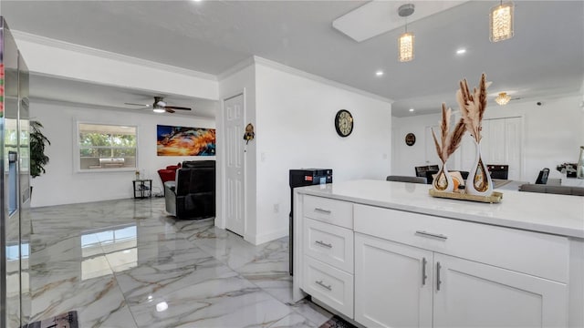 kitchen with ceiling fan, white cabinets, hanging light fixtures, and ornamental molding