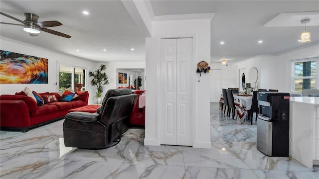 living room with plenty of natural light, ornamental molding, and ceiling fan