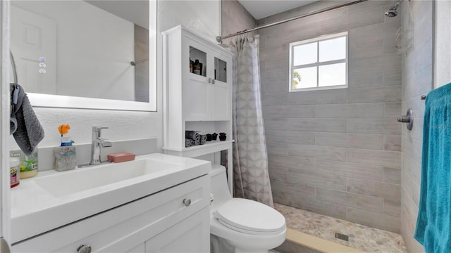 bathroom with a shower with shower curtain, vanity, and toilet