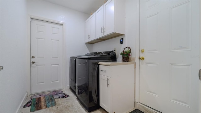 laundry area with washing machine and dryer and cabinets