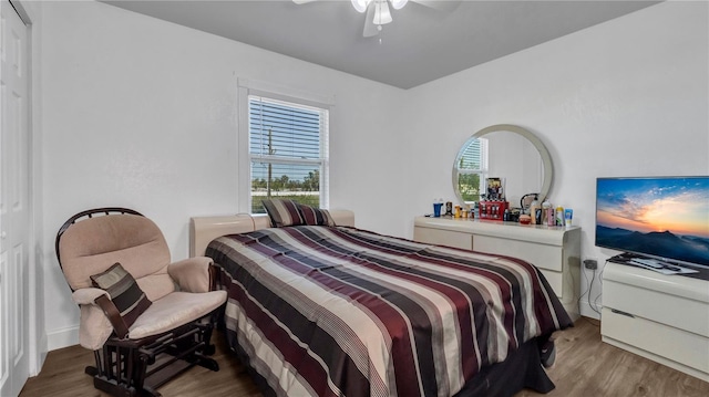 bedroom with hardwood / wood-style flooring, ceiling fan, and multiple windows