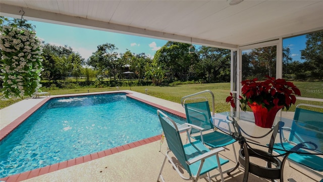 view of swimming pool featuring a yard and a patio