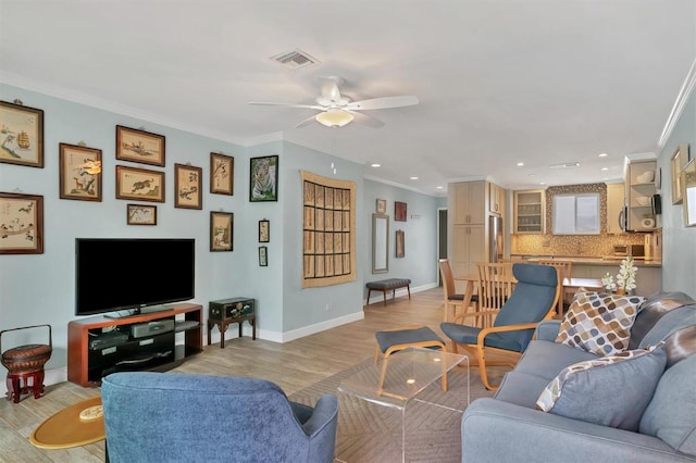 living room with ceiling fan, crown molding, and light hardwood / wood-style floors