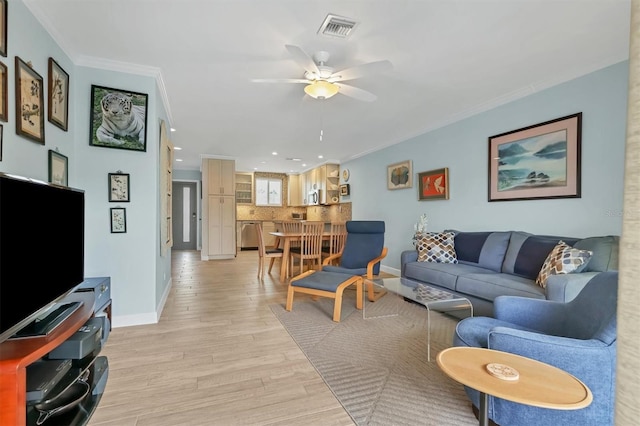 living room with light hardwood / wood-style floors, ceiling fan, and ornamental molding