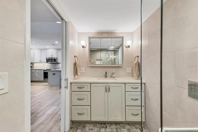 bathroom featuring backsplash, vanity, and hardwood / wood-style flooring