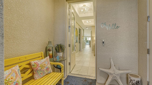 corridor with a chandelier and light tile patterned floors