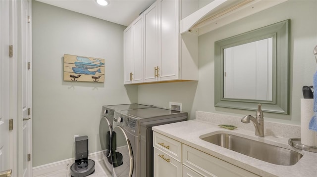 laundry area with washer and clothes dryer, sink, cabinets, and tile patterned flooring