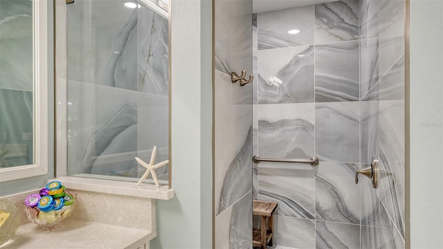 bathroom featuring a tile shower and vanity