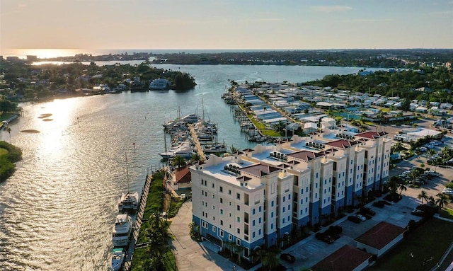 aerial view at dusk featuring a water view