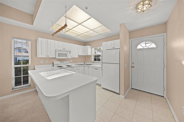 kitchen featuring kitchen peninsula, white appliances, white cabinetry, and sink