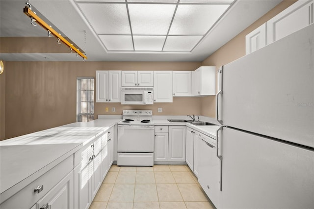 kitchen featuring light tile patterned floors, white appliances, white cabinetry, and sink