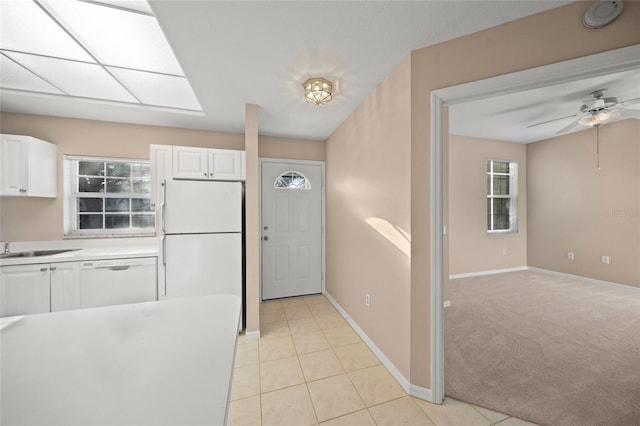 kitchen with white cabinets, ceiling fan, light colored carpet, and white appliances