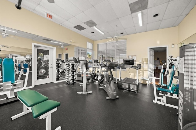 gym with a paneled ceiling and ceiling fan