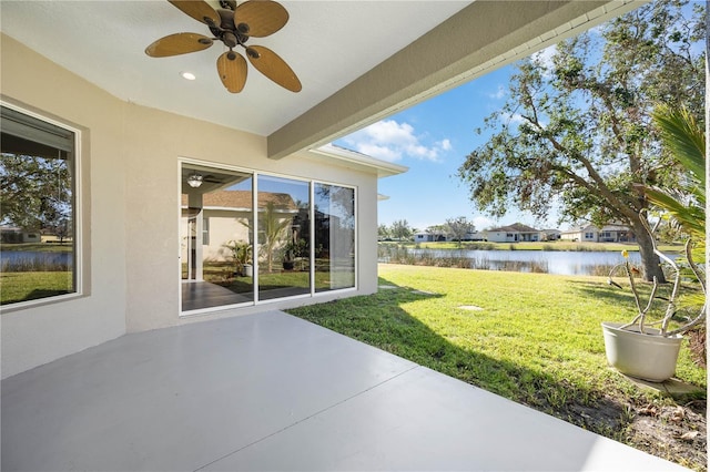 view of patio / terrace with ceiling fan and a water view