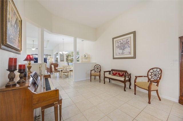 living area with vaulted ceiling, light tile patterned floors, and ceiling fan with notable chandelier