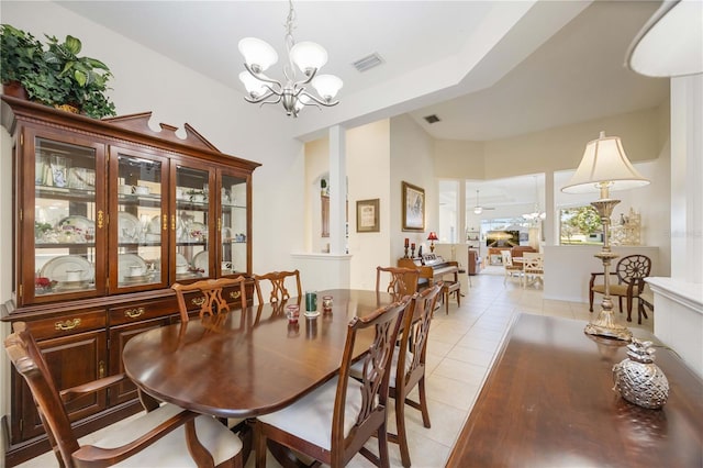 tiled dining room with a notable chandelier