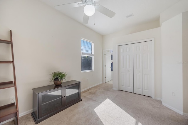 bedroom with ceiling fan, light colored carpet, and a closet