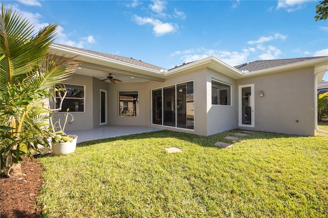 rear view of house with ceiling fan, a patio area, and a yard