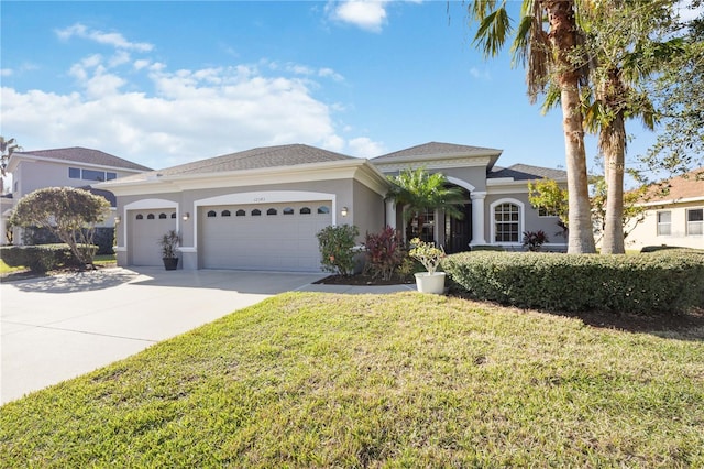 view of front of house with a front lawn, concrete driveway, an attached garage, and stucco siding