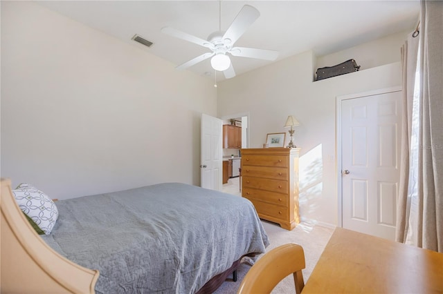bedroom featuring a ceiling fan, visible vents, and light carpet