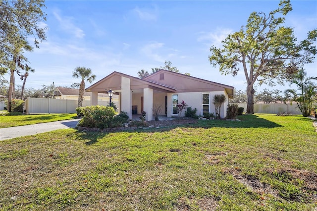 view of front of property with stucco siding, fence, and a front yard