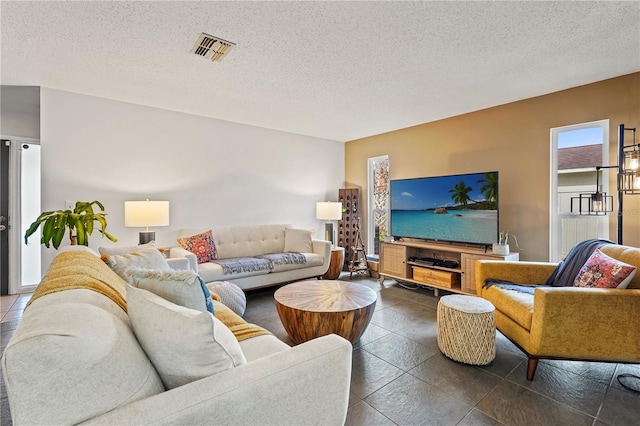 living area with visible vents and a textured ceiling