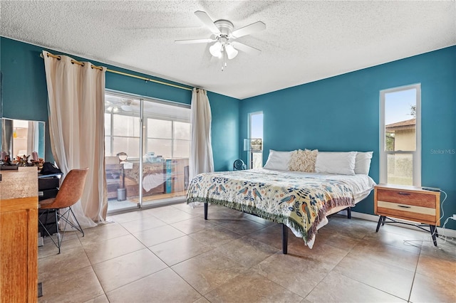 bedroom with access to exterior, ceiling fan, and a textured ceiling