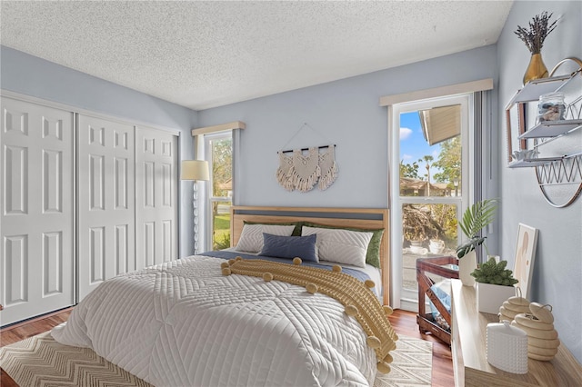 bedroom featuring a textured ceiling, a closet, and wood finished floors