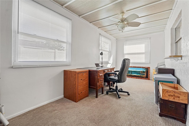 office space featuring plenty of natural light, baseboards, ceiling fan, and light colored carpet