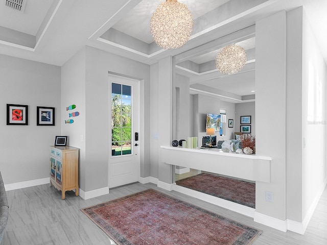 entrance foyer with a raised ceiling and a chandelier