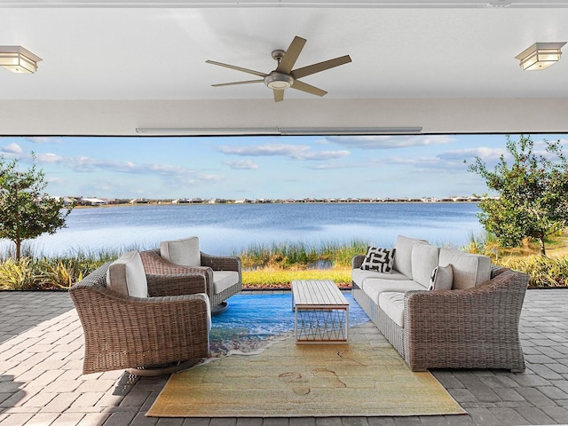 view of patio / terrace with ceiling fan, a water view, and an outdoor living space