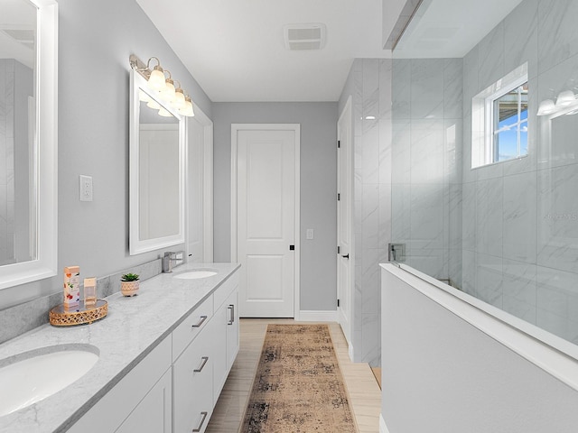 bathroom with vanity and tiled shower