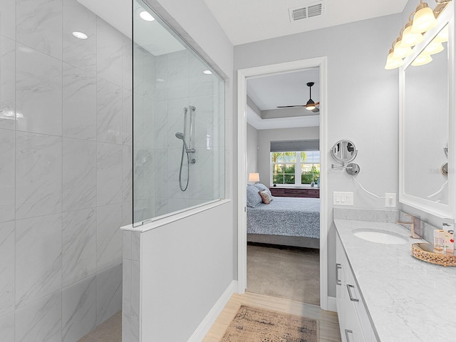 bathroom featuring a tile shower, vanity, and ceiling fan