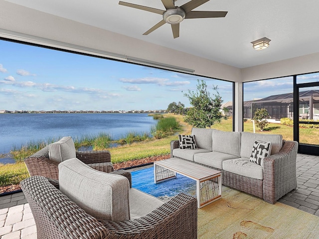 view of patio / terrace featuring ceiling fan, a water view, and an outdoor living space