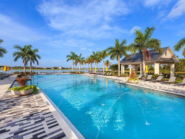 view of pool with a water view and a patio