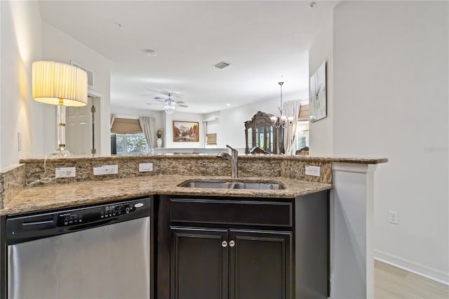 kitchen featuring light stone countertops, sink, stainless steel dishwasher, ceiling fan with notable chandelier, and light wood-type flooring