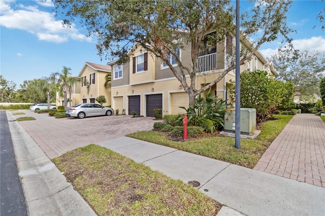 multi unit property with a balcony and a garage