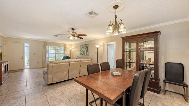 tiled dining space featuring a textured ceiling, ceiling fan with notable chandelier, and crown molding